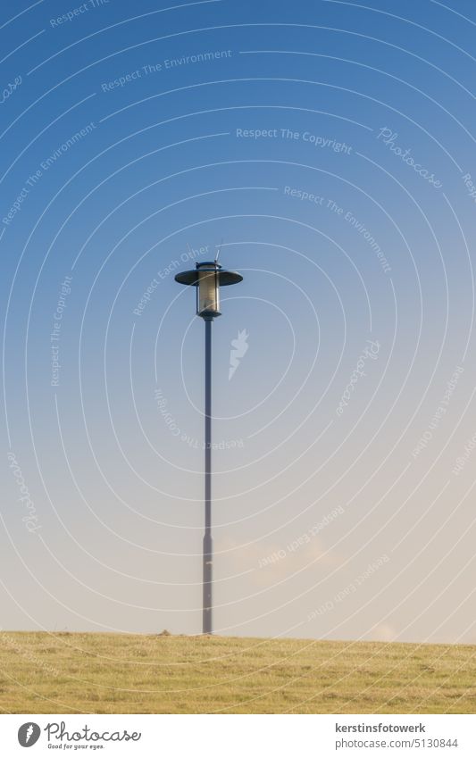 A lonely lantern on the dune on the dike Lantern Light Street lighting Blue Deserted Exterior shot Lamp post Clouds Sky Colour photo streetlamp Lonely