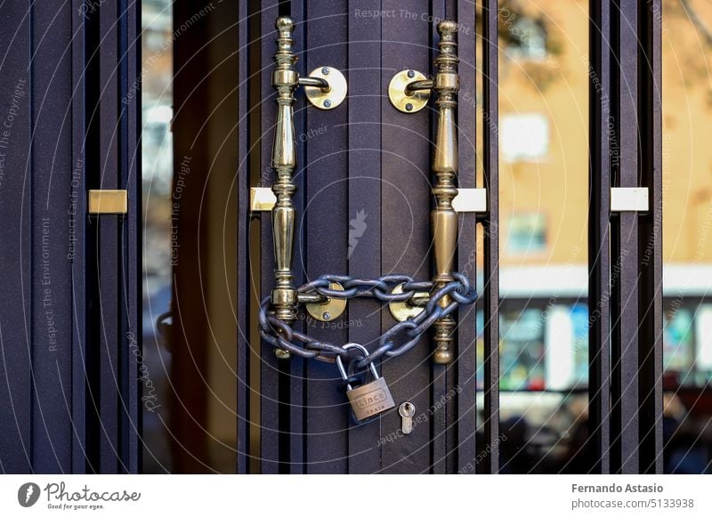 Padlock. String. Padlock on a portal of a building so that the neighbors cannot access it. Affected by line 7B of the San Fernando de Henares metro, in the Community of Madrid, Spain.