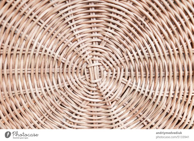 Circular weave rattan pattern, round rattan furniture background light brown texture, weave rattan texture and background. a fragment of a basket made of willow twigs or garden furniture, texture.