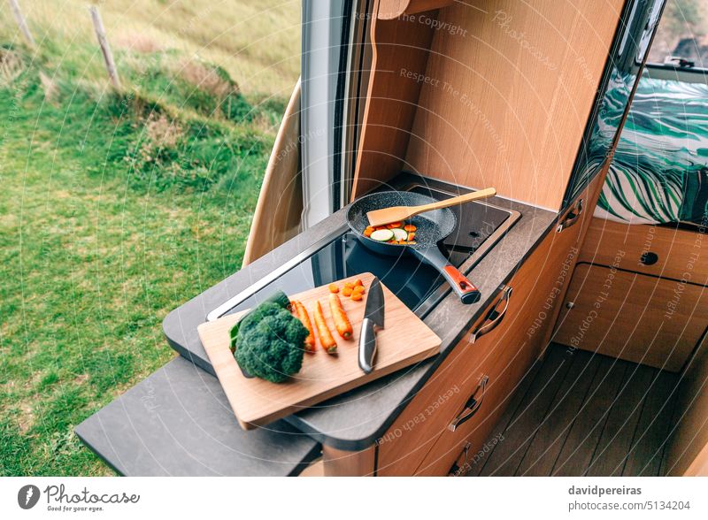 Vegan meal preparation in a campervan vegan cooking camper van vegetable nobody no people cutting board knife zucchini carrot broccoli food trip journey trailer