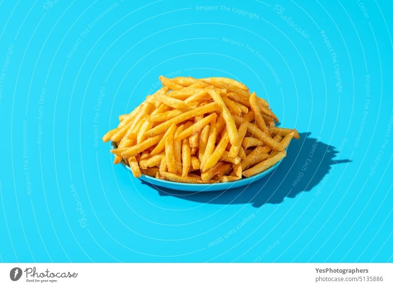 French fries plate minimalist on a blue background. abundance bright calories chip close-up color colorful comfort food concept copy space crispy cuisine