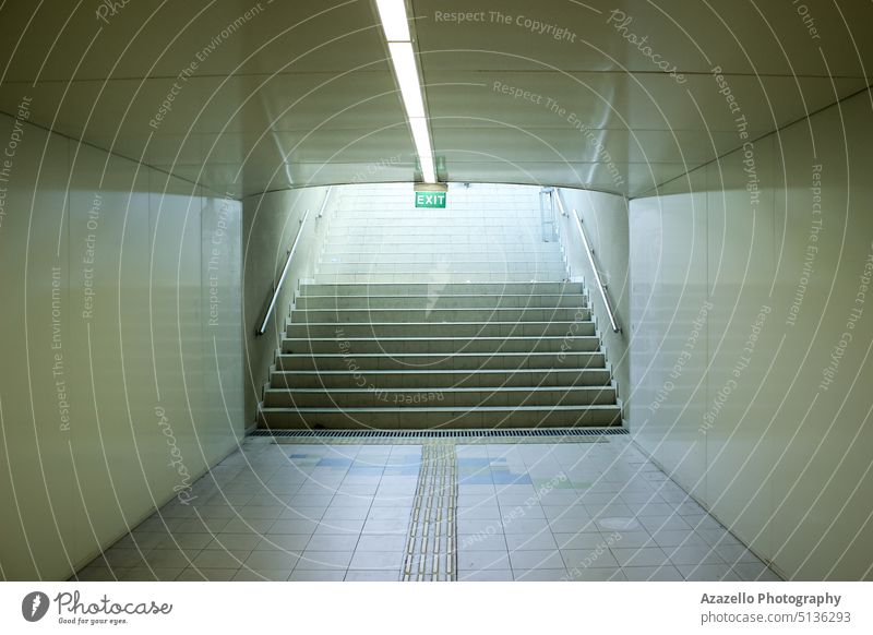 Underground passage with an exit sign over the staircase. aim architecture blank board bright building clean concept construction decision design future goal