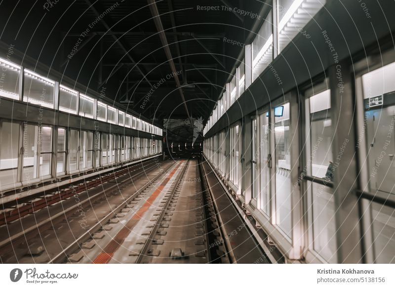 Front cabin view of moving subway carriage between airport terminals. Riding driverless metro train in Barcelona. Advanced transportation system, underground tunnel.