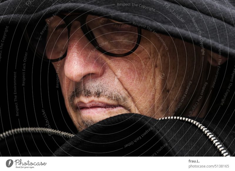 hood Attractive Dark portrait Winter Hooded (clothing) Coat Eyeglasses Face Facial hair Old Man Café Bistro Cold crease wrinkle Head Sit