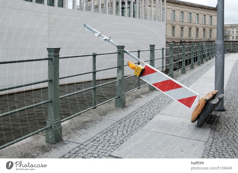 overturned sloping guide beacon on footpath and bank reinforcement Guide beacon obliquely cordon toppled over Gale Red Safety Topple over Protection