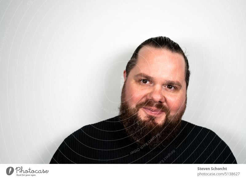 Man with beard and braid looks at camera with light smile Facial hair Braids portrait Adults Colour photo Human being Looking into the camera Face Head Day