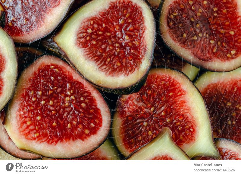 Macro photograph of cut ripe figs. fruit vitamin vegetarian nutrition seed macro red purple half healthy freshness close-up group still life lifestyle