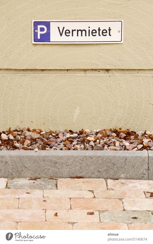 Sign - P Rented - on the wall of the house behind a parking area made of concrete pavement Parking lot Clearway sign Tenant parking concrete paving Paving stone