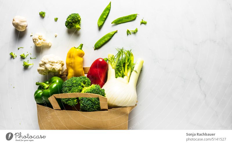 Fresh raw vegetables in a paper shopping bag on a table. View from above. Vegetable Raw Colour photo Vegetarian diet Diet Shopping bag Paper Reusable