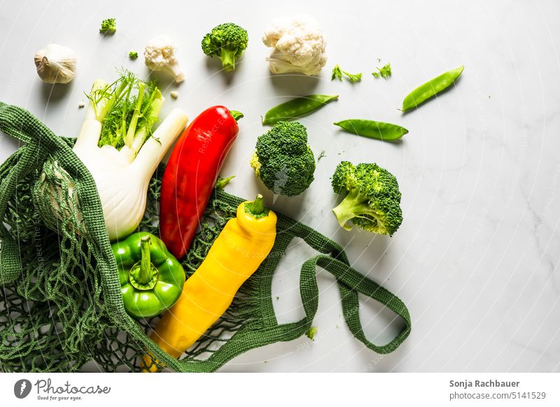 Fresh vegetables in a shopping net on a gray table. View from above. Vegetable Raw Diet Vegetarian diet Healthy String bag Reusable plastic-free Organic