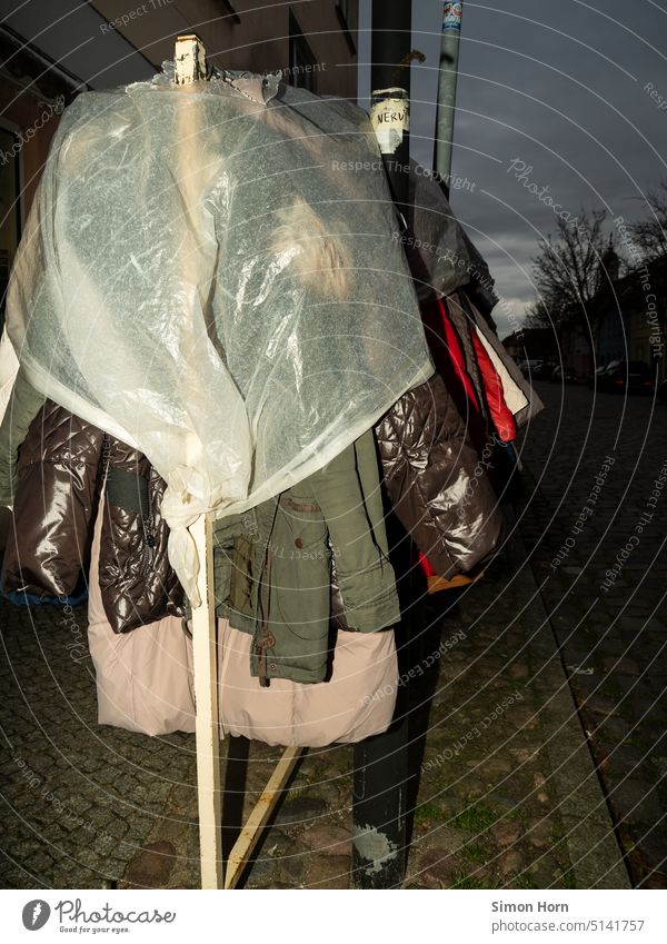 Second hand clothes under plastic film second hand garments rain shelter Second-hand Flea market Sell Clothing Exterior shot Fashion Second-hand shop Rain