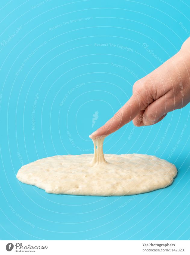 Sourdough starter isolated on blue background. Testing the yeast active bakery baking bread bright bubbles close-up color concept cooking cuisine diet ferment