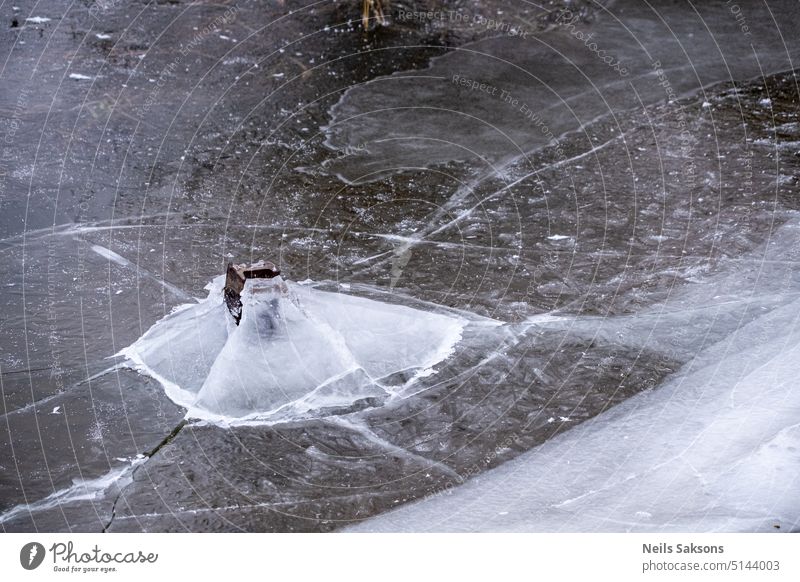 breaking ice from under water river frost freeze winter crack no snow snowless Lake pieces broken ice slippery dangerous thin ice skate