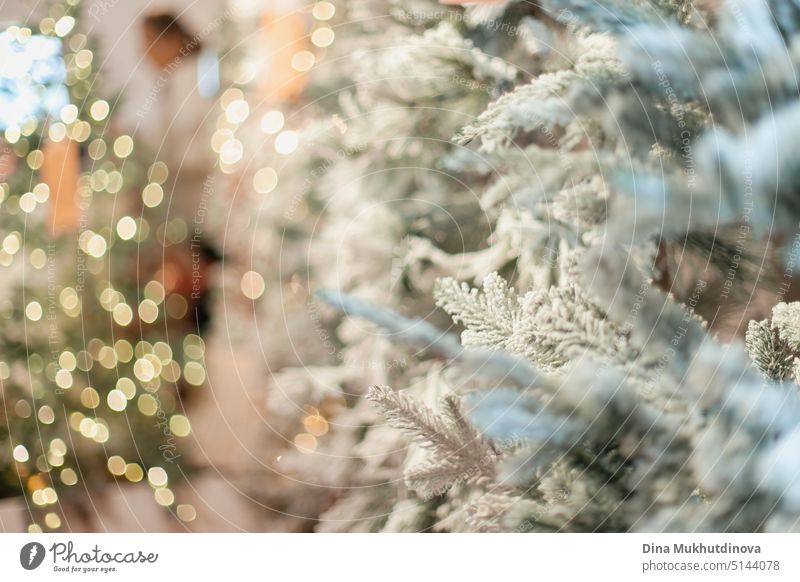 white faux christmas tree decorated with light bokeh at store or shop or festive market. Empty minimal green fir tree background abstract aged backdrop card