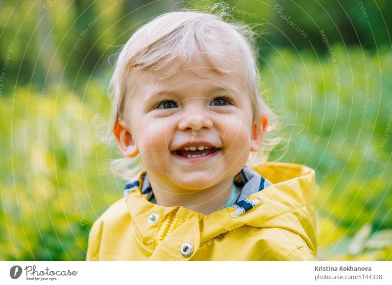 Portrait of cute baby boy in yellow raincoat. Child smiling. Love, care, attachment, family, children concept. person portrait childhood kid joy little small