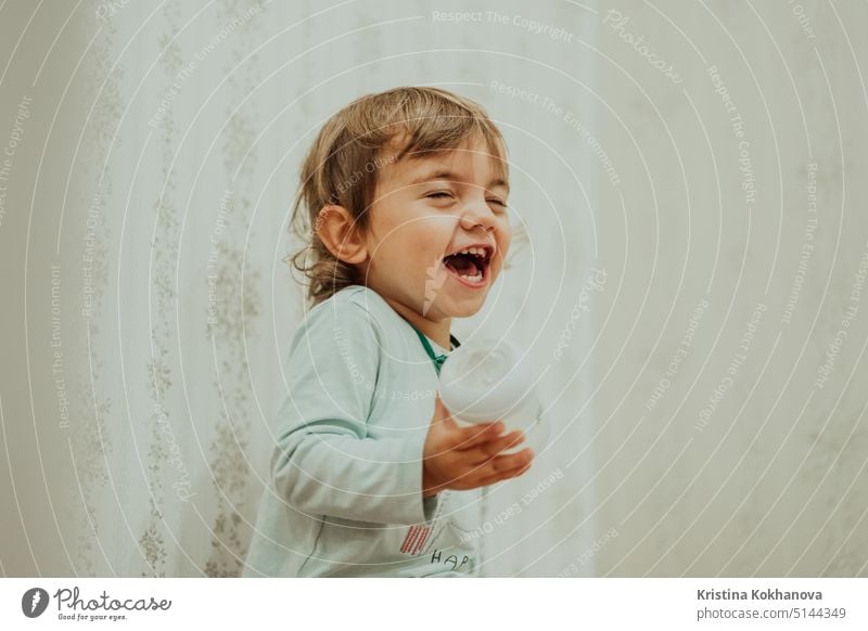 Adorable baby boy sincerely smiling, laughs contagiously. Cute toddler portrait at home. person child fun happy face young little laughing youth happiness joy