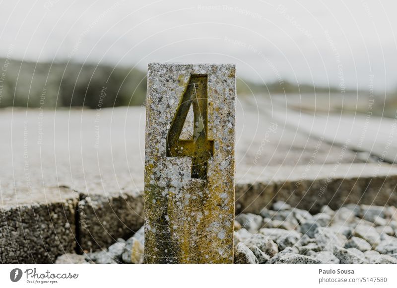 Stone column with Number 4 Column number Digits and numbers Signs and labeling Characters Numbers Deserted Colour photo Day Detail Close-up Black Subdued colour