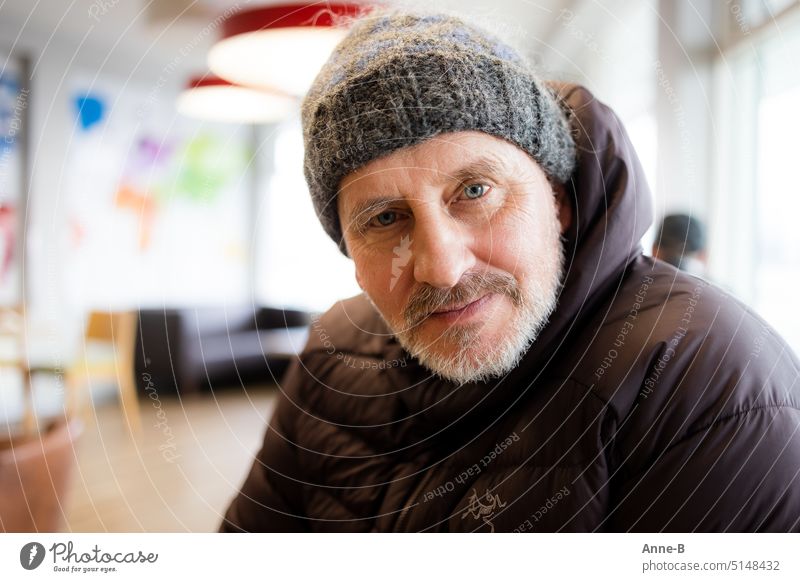 friendly man in his mid-fifties with beard, wool cap and thick jacket looks at me in a gas station bistro Man portrait Mid-Fifties Winter Wintertime Tankebistro