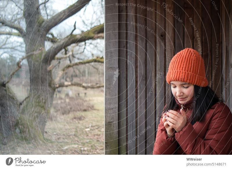 A young woman rests on a winter hike and warms her hands on a warm tea mug chill Warmth Winter out Nature Hiking Woman Girl youthful warm sb./sth. Freeze