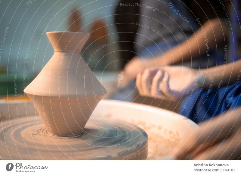 Working process of man's work at potters wheel in art studio. Unknown craftsman creates jug. Focus on hands only. Small business, talent, invention, inspiration concept.