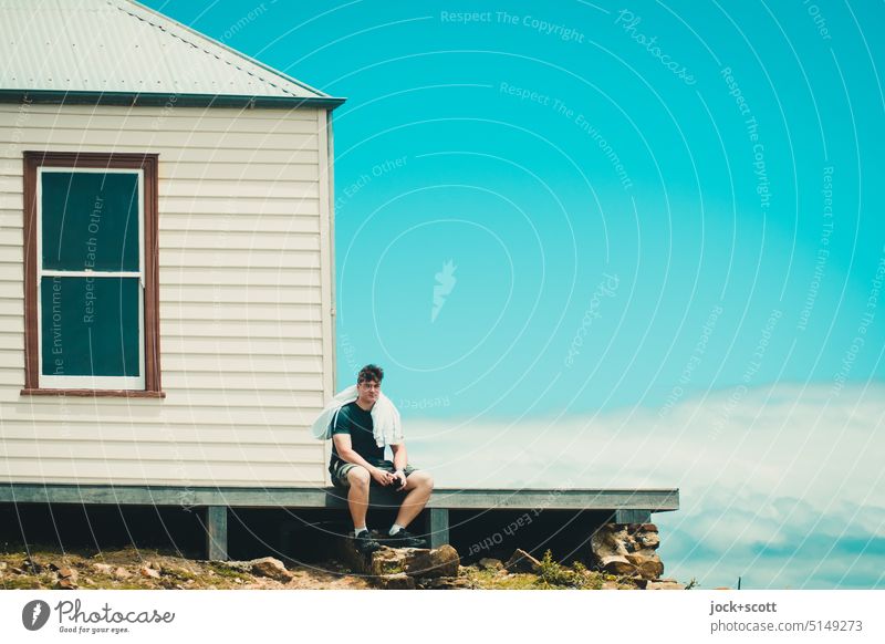 a well deserved break at Ruby Hunt's Cottage House (Residential Structure) Young man Window traditionally Sit Break Sky Clouds Roof Wooden wall Facade Platform