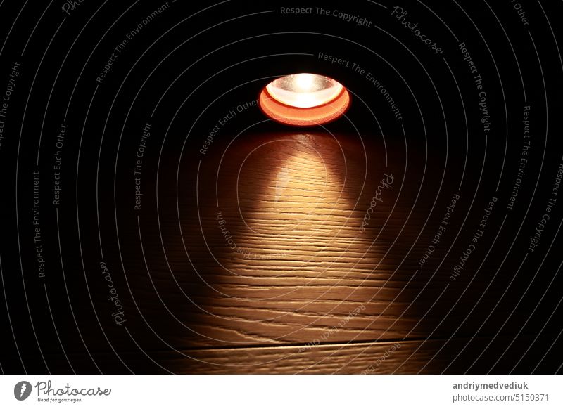 Flashlight and a beam of light in darkness. A modern led light with bright projection on dark wood table. Surface with copy space. power outage. collapse of the power system.