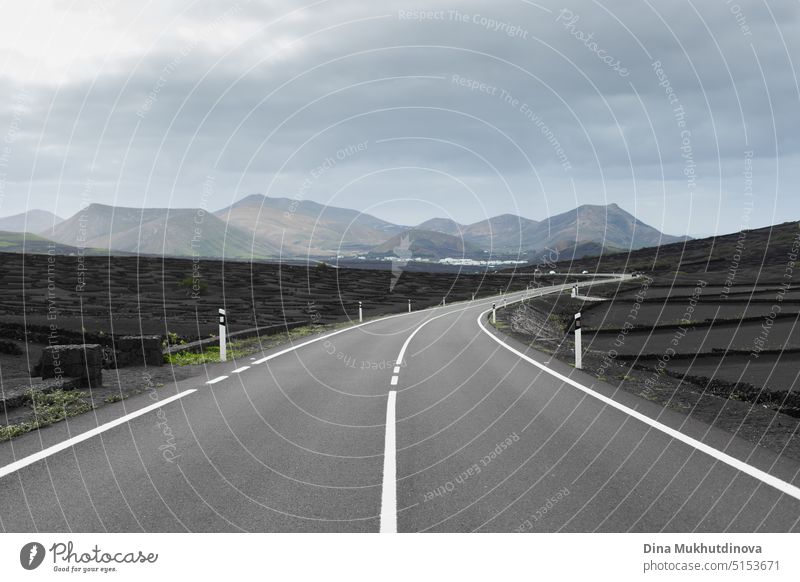 Empty road view with mountains view ahead. Volcanic scenery landscape of Lanzarote, Canary Islands, Spain. Road without cars. Road trip and sustainable tourism.