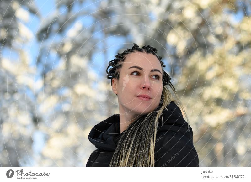 Woman with African braids and a hood smiling and looking to the side attractive authentic beautiful beauty black candid casual caucasian cheerful cold creative