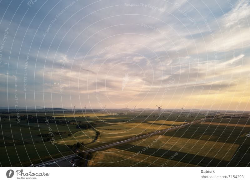 Road with car traffic and windmill turbines at sunset road silhouette alternative energy generator clean energy sustainable farm europe poland generation