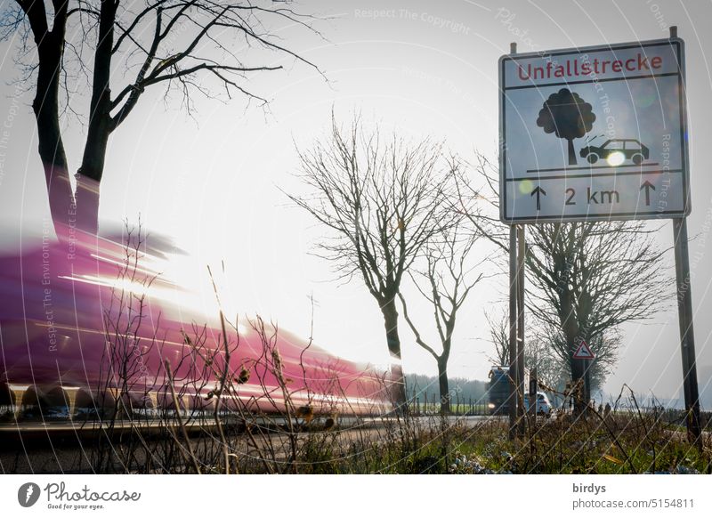 Accident section. Accident road section with warning sign and passing cars with motion blur. Route of accident accident-prone Street Warning sign