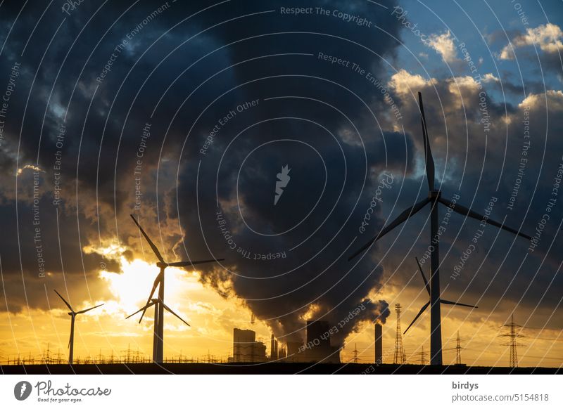 Coal phase-out. Lignite-fired power plant with wind turbines in the foreground at sunset coal exit Lignite power plant windmills climate crisis Climate change