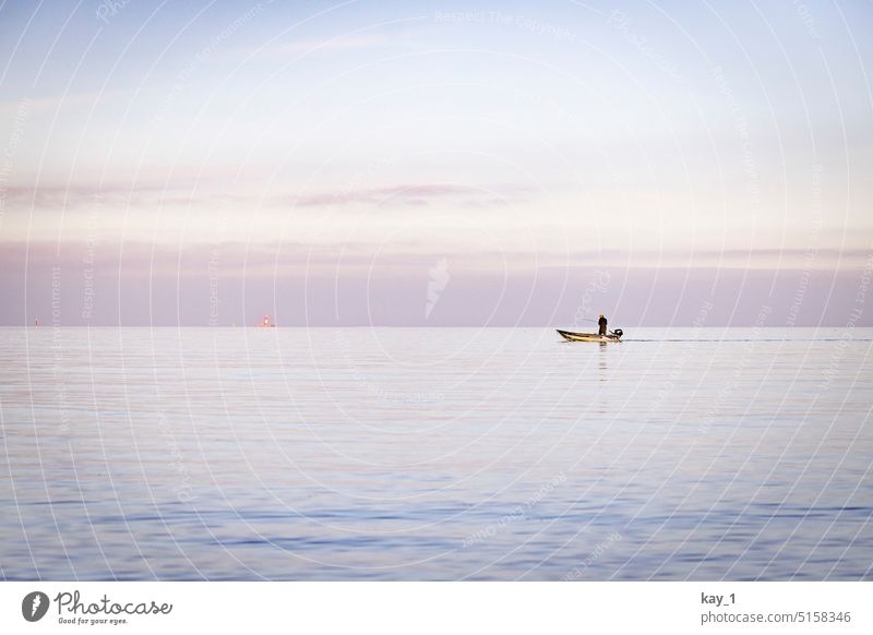 Fisherman in small motor boat fishing on the Baltic Sea Fishing boat Fishing (Angle) wide Exterior shot Ocean coast Lake North Sea Calm Water Lakeside Angler