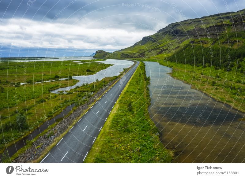 Iceland. Aerial view on mountain, field and river. Landscape in Iceland at the day time. View from drone. Summer. Cloudy weather. Fresh grass on field. Travel and vacation image