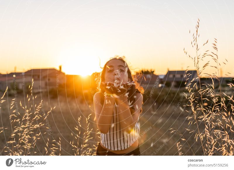 Young girl spying on straw in the field at summer adorable alone beautiful blow blowing caucasian child childhood children country cute day face female flower