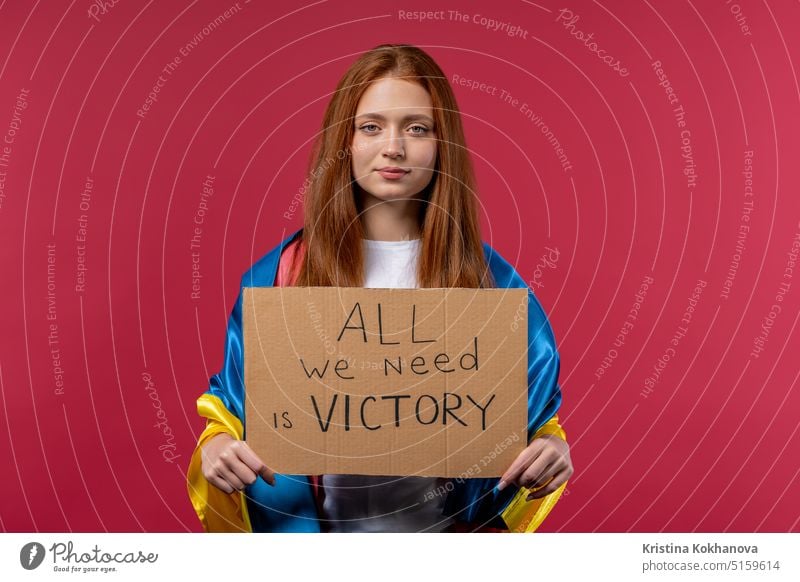 Ukrainian woman with cardboard All we need is victory on pink background. Ukraine win war. Democracy, liberty, demonstration, russian aggresion concept protest