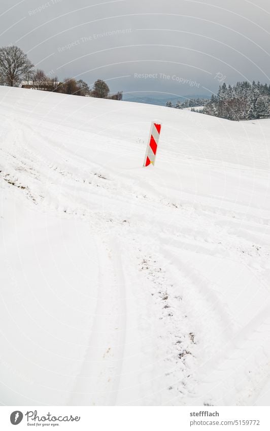 Red and white warning beacon lonely in white snowy landscape on the field Snow Construction site Winter Landscape Gray White Forest trees Sky Skid marks Eifel