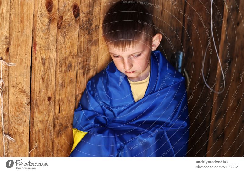 war russia against Ukraine. crying Ukrainian boy with the flag of Ukraine outdoors. Stop war. anti-war protest, cry depression despair, hope human peace, stressed terror warming fear