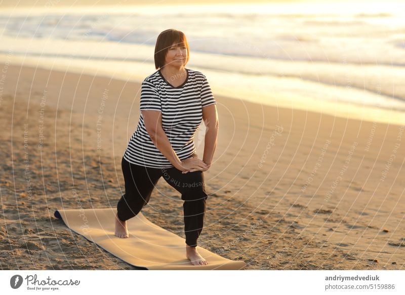 healthy yoga middle ages woman workout yoga pose on mat on the sandy beach at sunrise, benefits of natural environments for physical, spiritual, healthy, relaxing concept