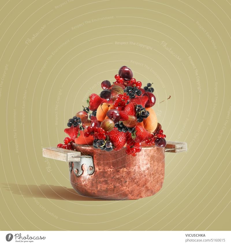 Copper cooking pot full with summer fruits and berries for jam making , front view copper strawberry sweet delicious food healthy