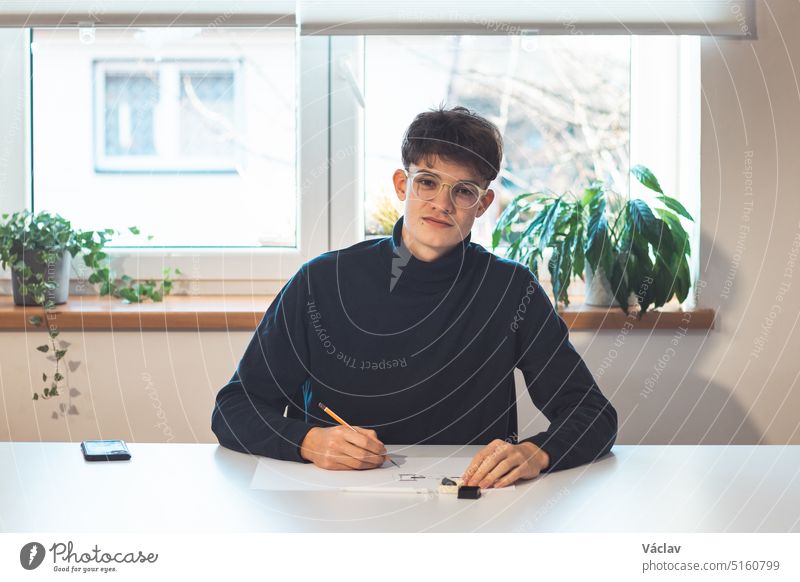 Brown-haired young architect creates new product designs for a new futuristic world. Working with your own creativity. Compass, pencil, ruler and paper. Creative home office