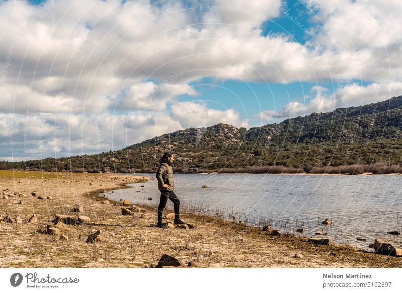 A man in the distance standing on the shore of a lake landscape winter mountain person slate beauty nature epic tree driftwood river morning architecture sky