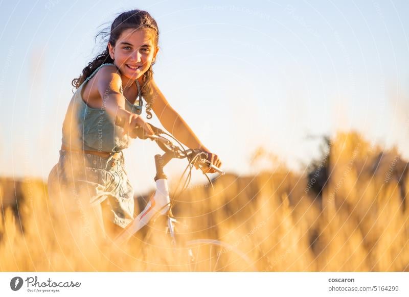 Cute girl with her bike at summer. active beauty bicycle biking blue sky caucasian child countryside cycling cyclist dry female field fit fun grass happiness