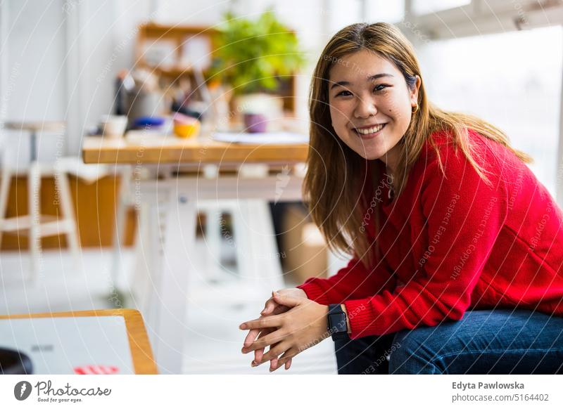 Portrait of a smiling creative woman sitting in a modern loft space real people millennials student indoors window natural girl adult one attractive successful