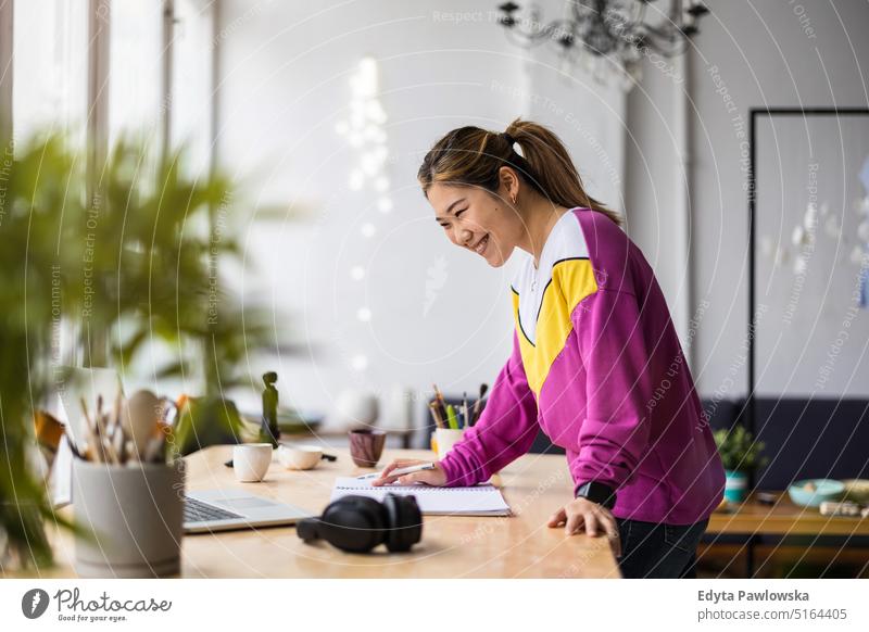 Young female freelancer working in loft office real people millennials student indoors window natural girl adult one attractive successful confident person