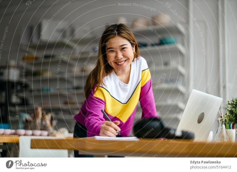 Young female freelancer working in loft office real people millennials student indoors window natural girl adult one attractive successful confident person