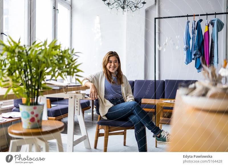 Portrait of a smiling creative woman sitting in a modern loft space real people millennials student indoors window natural girl adult one attractive successful