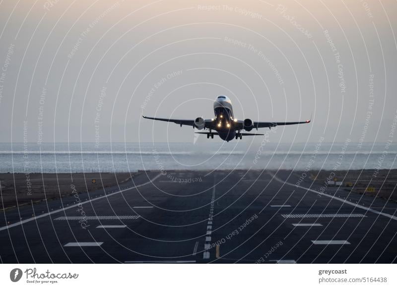 Plane taking off from the island airport airplane aircraft evening twilight jet aeroplane runway flight transport sky aviation headlights parking lights vehicle