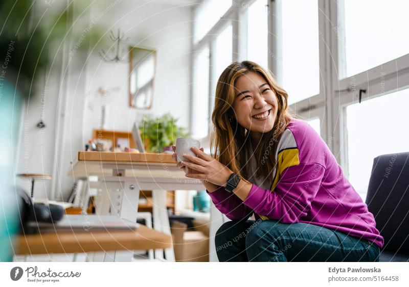 Portrait of a smiling creative woman sitting in a modern loft space real people millennials student indoors window natural girl adult one attractive successful