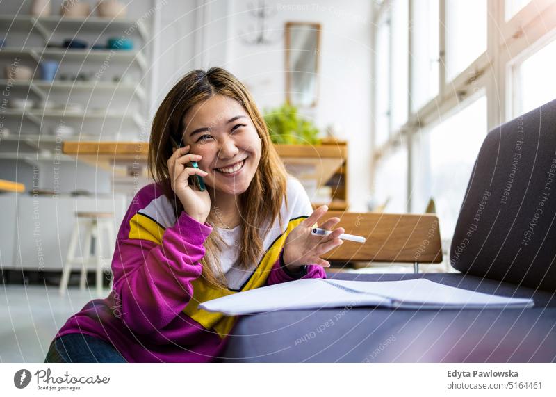 Young woman using smartphone in loft office real people millennials student indoors window natural girl adult attractive successful confident person beautiful