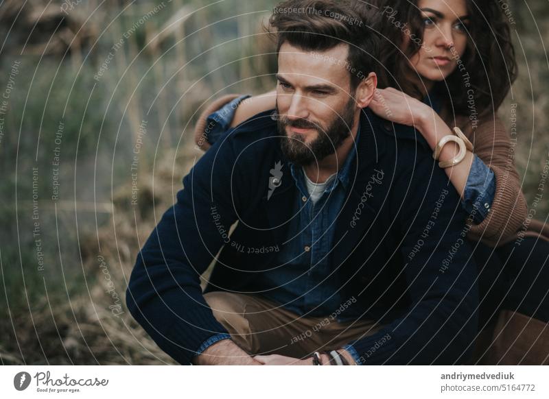 portrait of two caucasian lovers. Young couple is hugging on autumn day outdoors. A bearded man and curly woman in love. Valentine's Day. Concept of love and family.